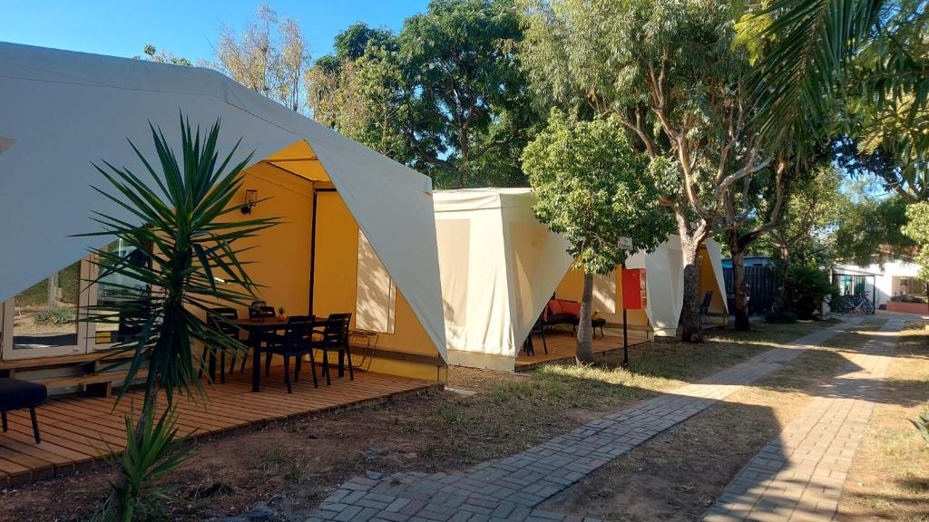 een gele en witte tent met een tafel op een dek bij Camping Bella Vista in Ceriale