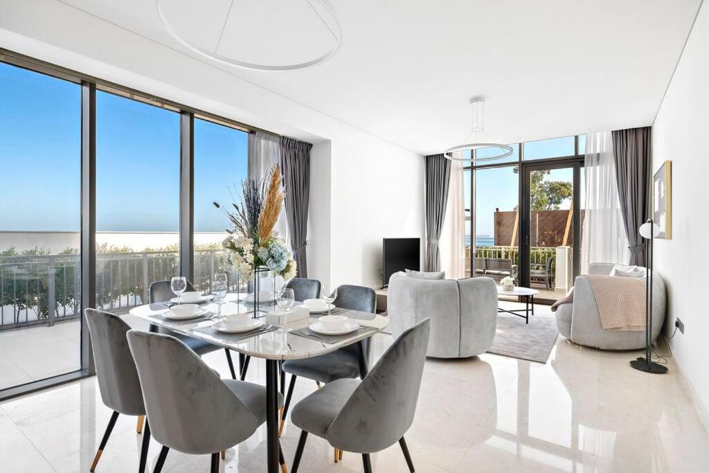 StoneTree - Anwa By Omniyat 2BR - Luxury Apartment في دبي: غرفة طعام مع طاولة وكراسي