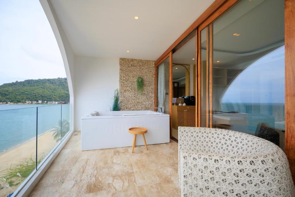 y baño con bañera, mesa y silla. en Luxury Penthouse - Khanom en Ban Plau