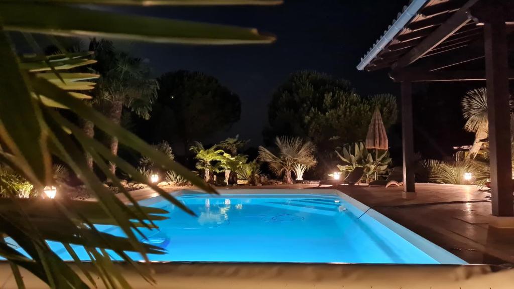 a swimming pool in a backyard at night at Le Relais des Chevaliers " Chambre des Chevaliers" in Cordes-sur-Ciel