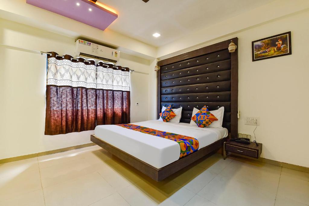 um quarto com uma cama grande e uma janela em FabHotel Crystal Inn II em Ahmedabad