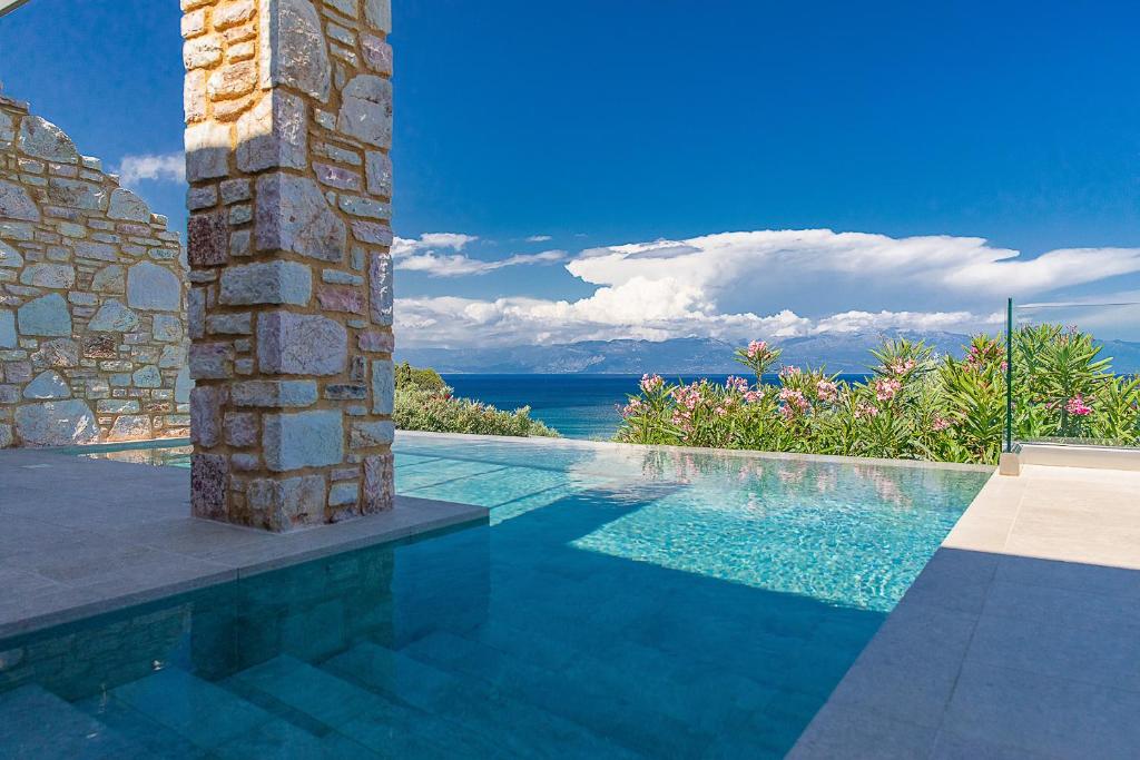 a swimming pool with a view of the ocean at Colonides Beach Hotel in Vounaria