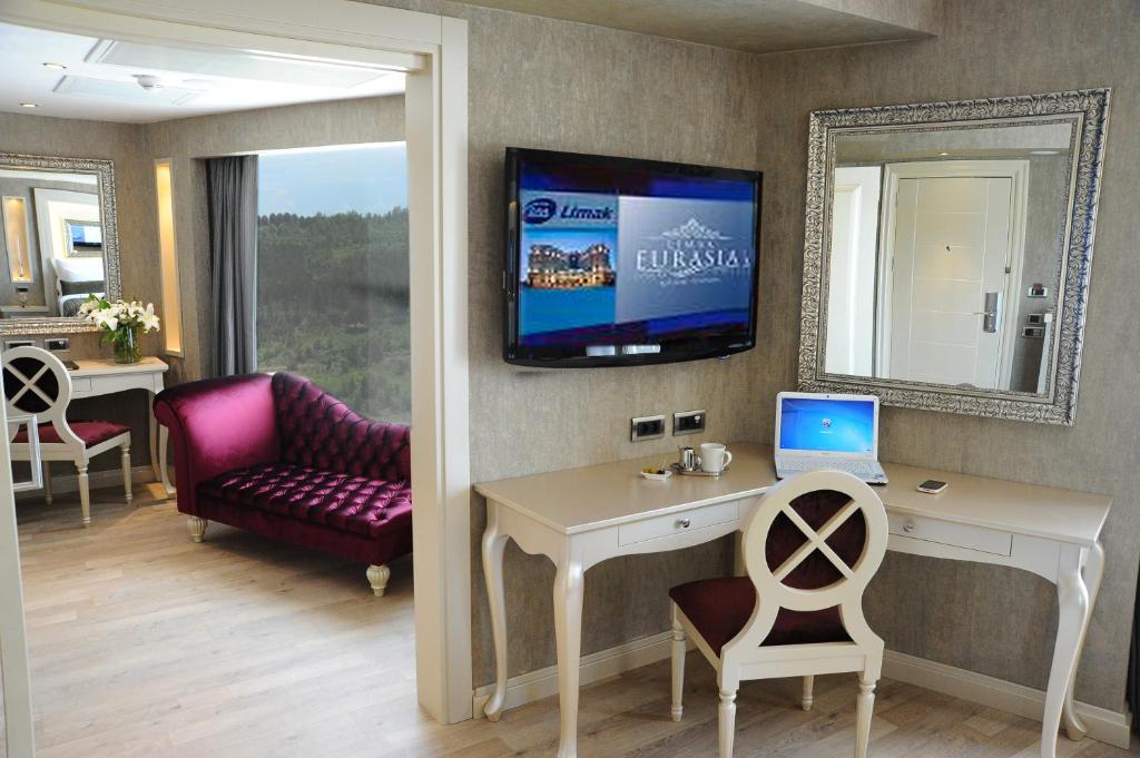 a room with a desk and a tv on the wall at Limak Eurasia Luxury Hotel in Istanbul