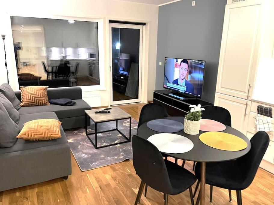 a living room with a couch and a table with chairs at Scandpoint Apartment Lillestrom -Cosy 3 rooms flat with free Parking, EV Charger 18 min from Airport in Lillestrøm