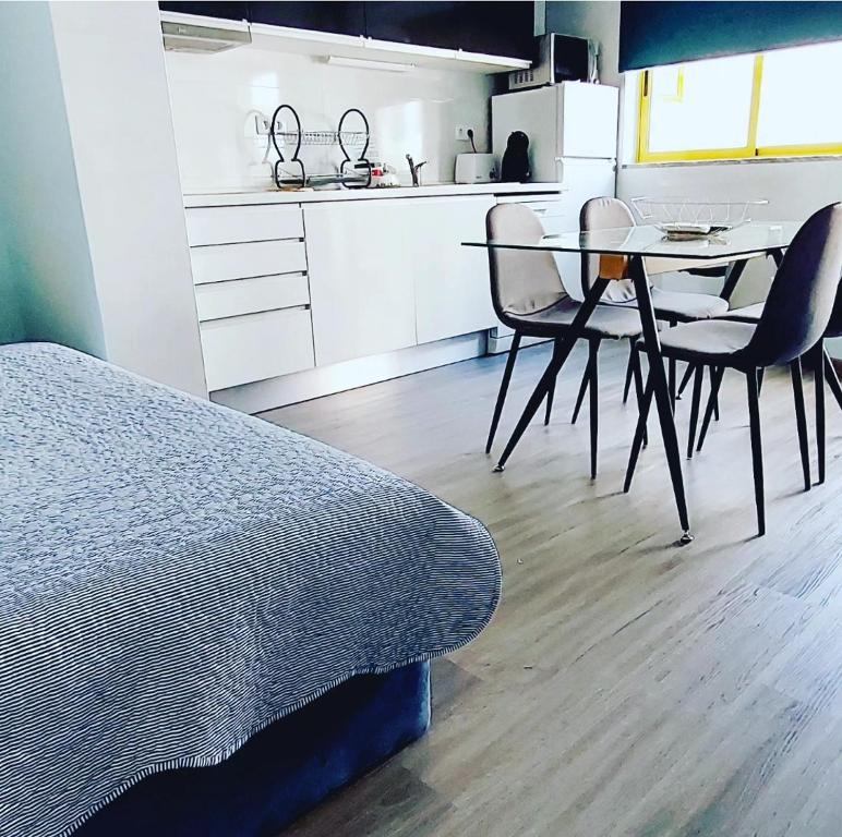 a bedroom with a table and chairs and a kitchen at CPR SolNascente in Portimão