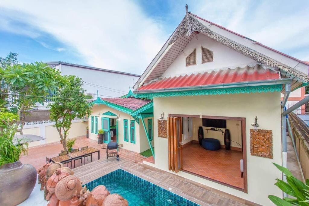 a house with a swimming pool in front of it at The Rain tree, Pool villa Pattaya in Pattaya Central