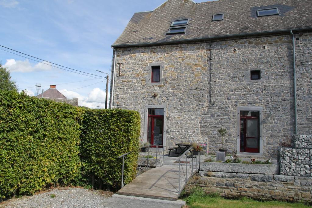 a stone house with a staircase leading up to it at Le Grenier de la Floye - Gîte Coquelicot in Mettet