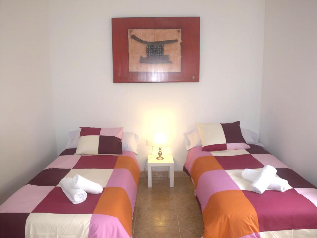 two twin beds in a room with a picture on the wall at Jardines del Ebro, 8 Pax, ideal grupos y centrico in Logroño