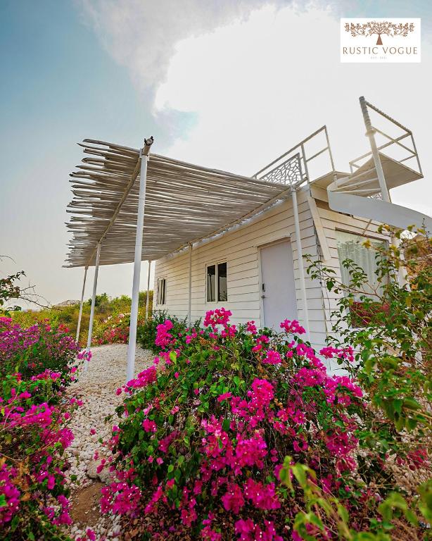 a white house with pink flowers in front of it at RUSTIC VOGUE in Shamirpet