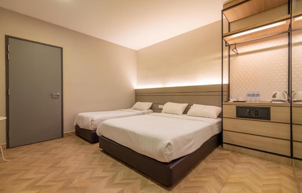 een slaapkamer met 2 bedden en een dressoir bij Bpod at Setapak KL in Kuala Lumpur