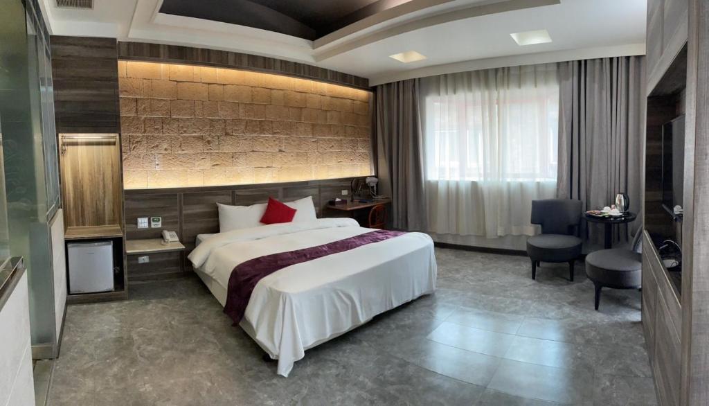 um quarto de hotel com uma cama grande e uma secretária em Alia Motel em Sanxia