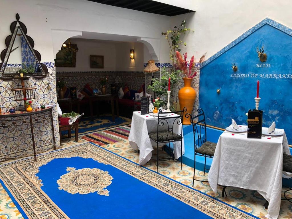 a room with two tables and a blue wall at Riad Lazorde De Marrakech in Marrakesh