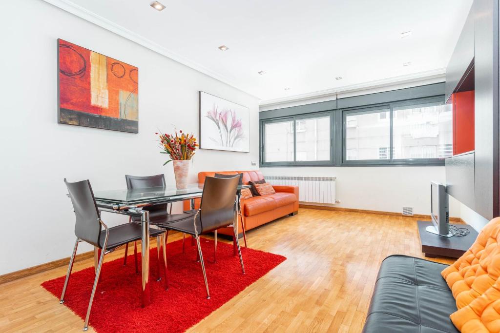 a living room with a table and chairs and a couch at Apartamento con garaje in Luanco