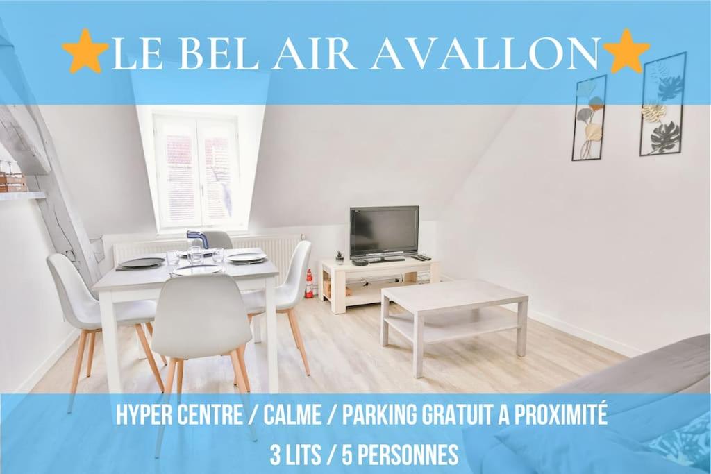 a white living room with a table and a tv at Le Bel-Air AVALLON in Avallon