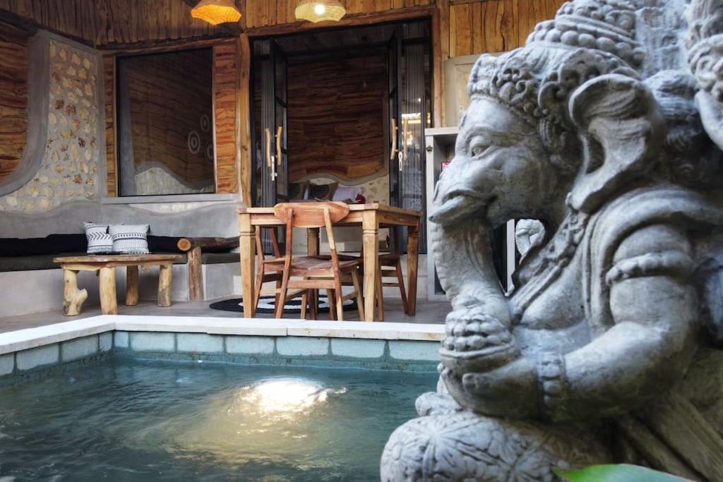 uma estátua sentada ao lado de uma piscina numa casa em Alma Villa 2 - Lovely 1 Bedroom with Pool em Uluwatu