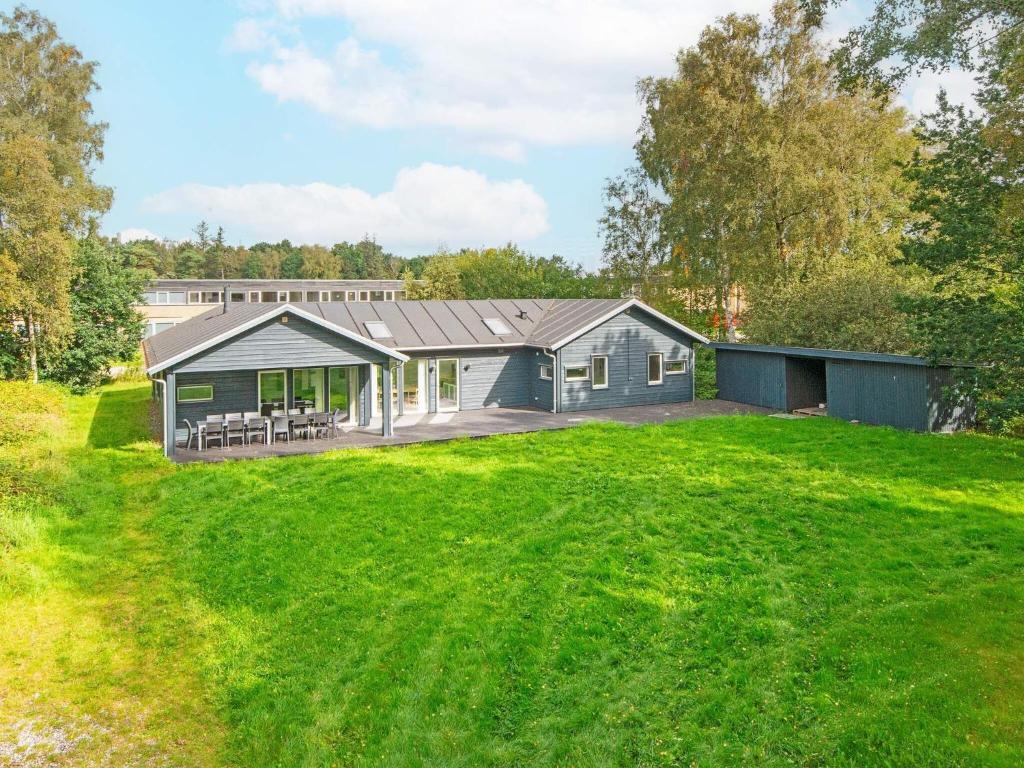 a house with a large lawn in front of it at 14 person holiday home in Grenaa in Grenå
