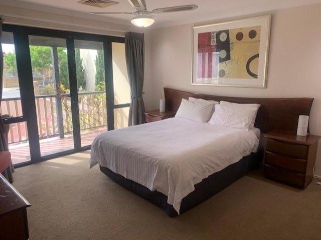 a bedroom with a large bed and a balcony at Super spacious Fremantle Villa 3 Bedrooms 3 Bathrooms in Fremantle