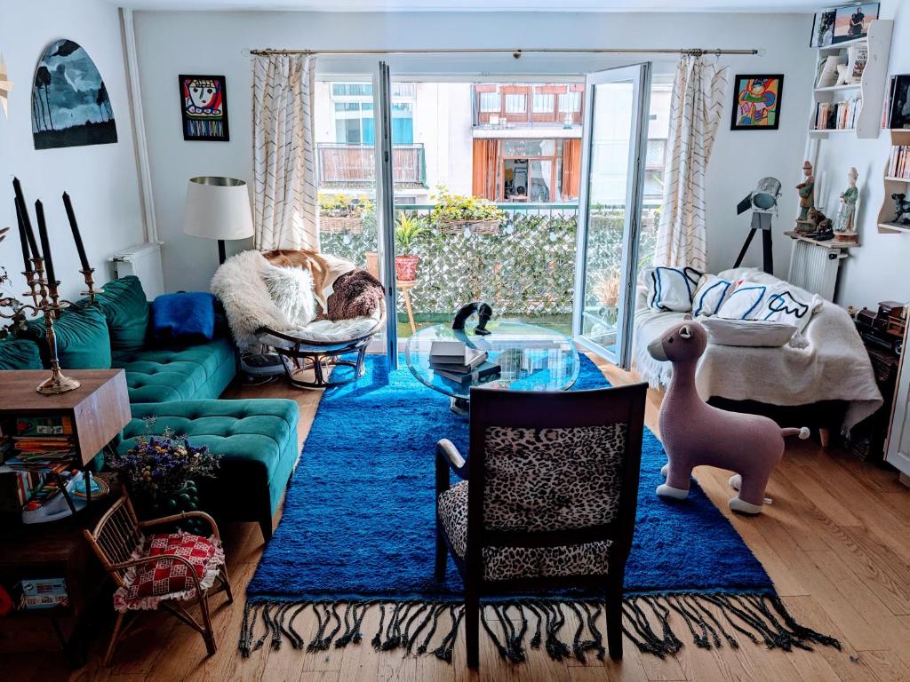 - un salon avec un canapé vert et un tapis bleu dans l'établissement Appartement avec balcon proche de Montmartre, à Paris