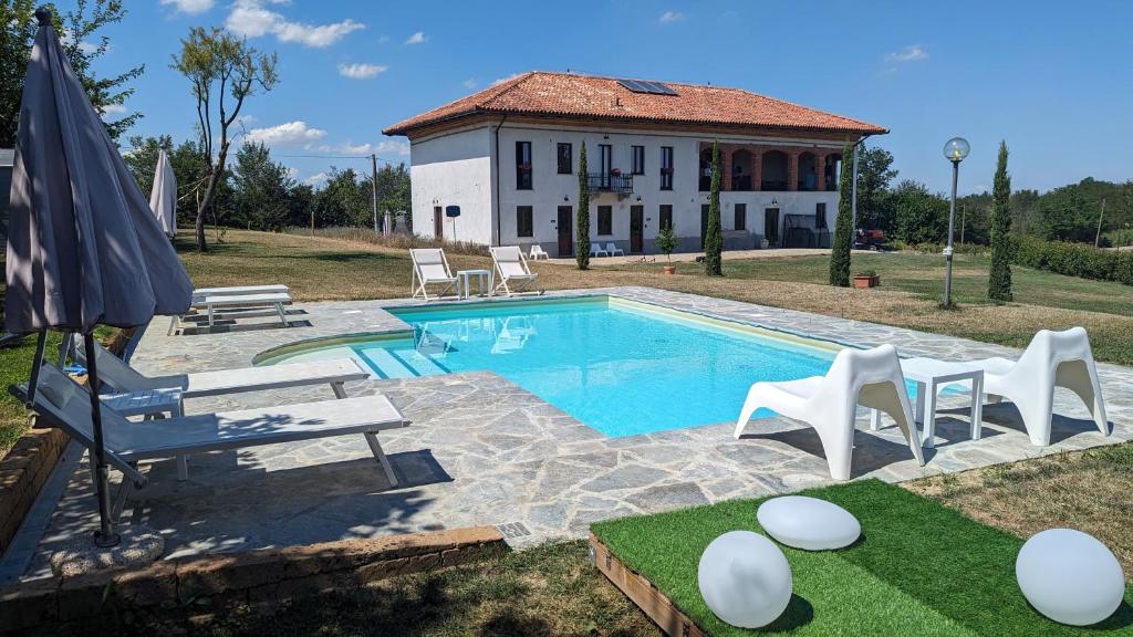 una piscina con sillas y una casa en el fondo en Casa Felmar, en Incisa Scapaccino