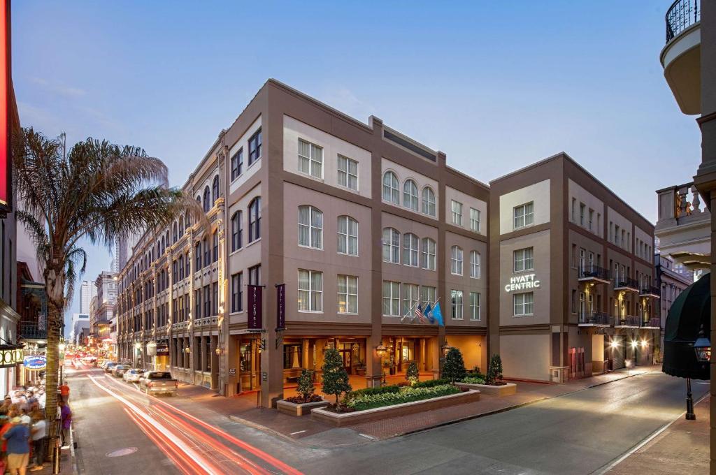 a large building on a city street with traffic at Hyatt Centric French Quarter in New Orleans