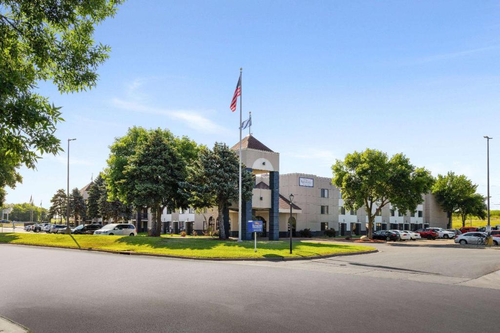 un edificio con una torre de reloj con una bandera. en Baymont by Wyndham Shakopee, en Shakopee