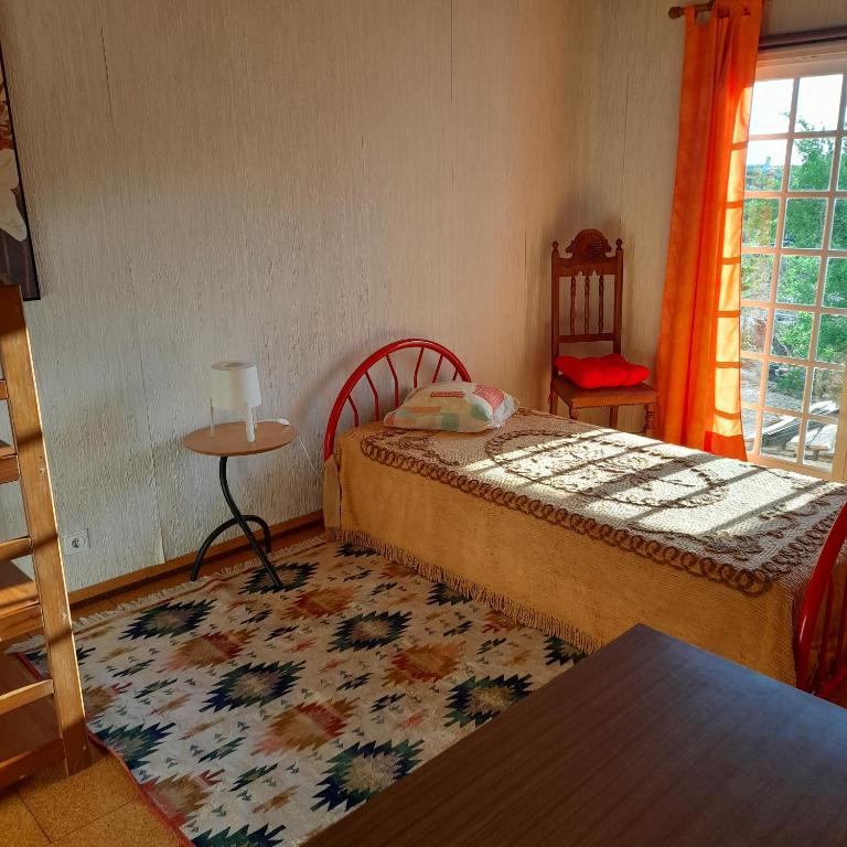 EstanqueiroにあるQuarto Individual em Foros de Salvaterraのベッドルーム1室(ベッド1台、テーブル、窓付)