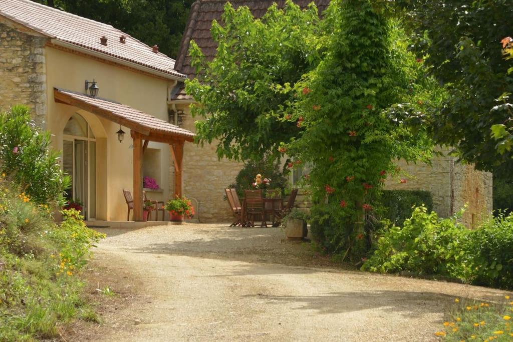 une maison avec une table et des chaises devant dans l'établissement Votre gîte en Périgord : La Grangette., à Sauveterre-la-Lémance