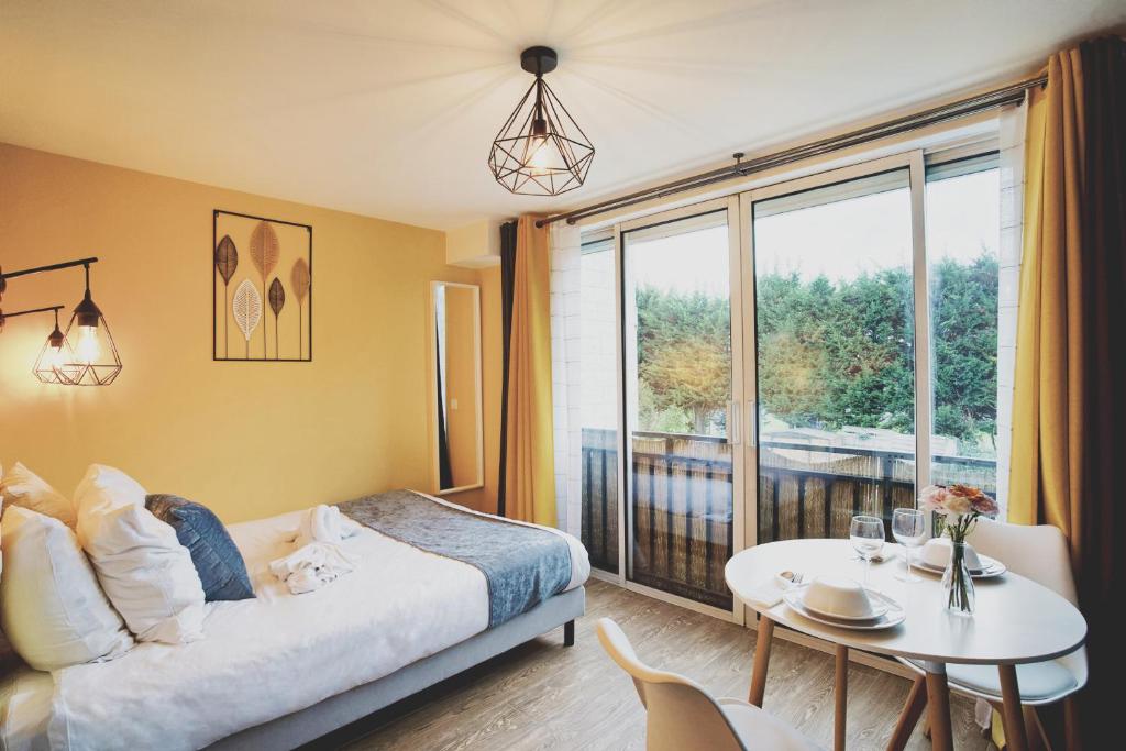 a bedroom with a bed and a table and a window at Cosy Aulnay- Paris Nord-Expo Villepinte in Aulnay-sous-Bois