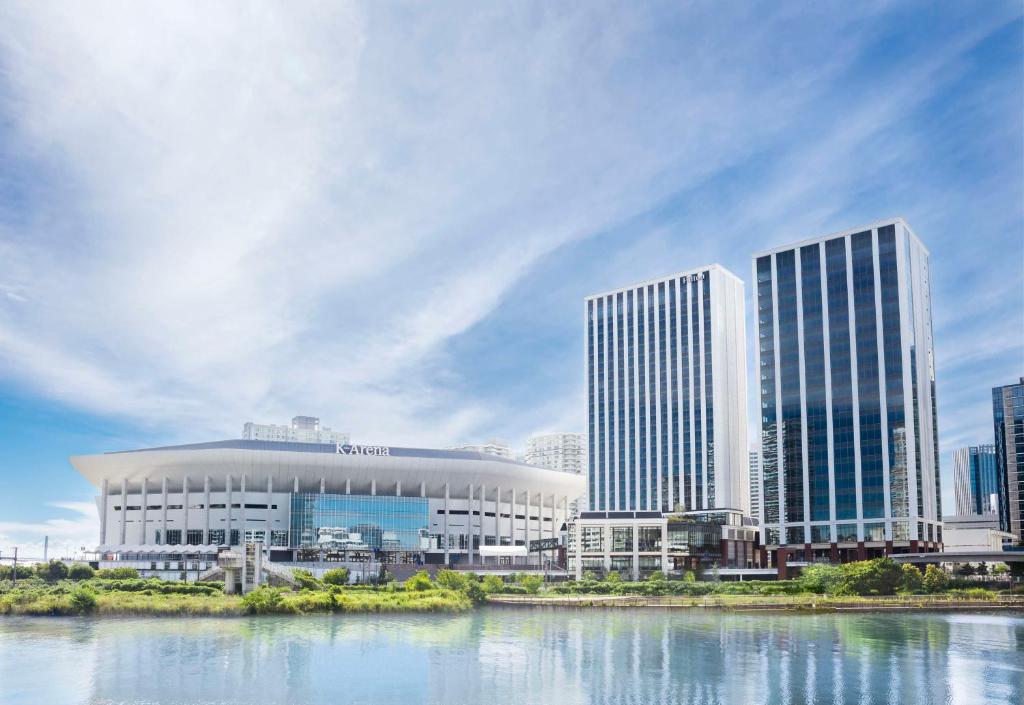 un grupo de edificios altos junto a un cuerpo de agua en Hilton Yokohama, en Yokohama