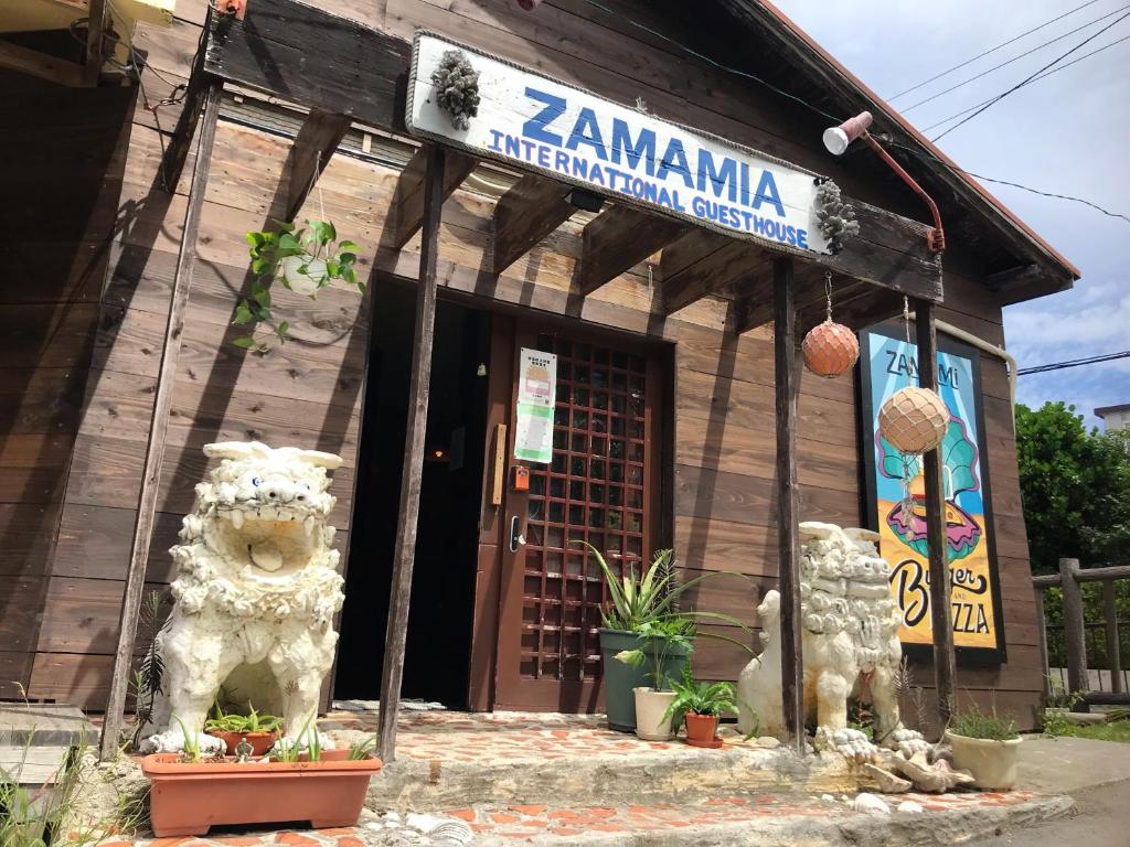 un bâtiment avec un panneau indiquant l'internationalisation de la zambiana dans l'établissement Zamamia International Guesthouse, à Shimajiri