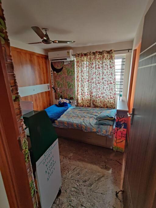 een kleine slaapkamer met een bed en een raam bij a 1bhk full service appartment entire house in Bangalore