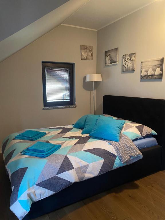 sypialnia z łóżkiem z kolorową kołdrą w obiekcie Hire House w Pobierowie