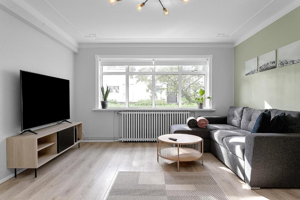 a living room with a couch and a flat screen tv at Lali Full Apartment in Reykjavík