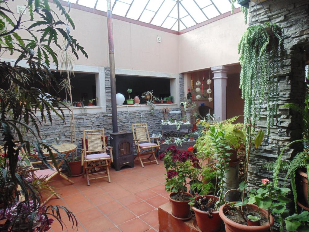 eine Terrasse mit Stühlen, Pflanzen und einer Steinmauer in der Unterkunft Quarto duplo em Foros de Salvaterra in Estanqueiro