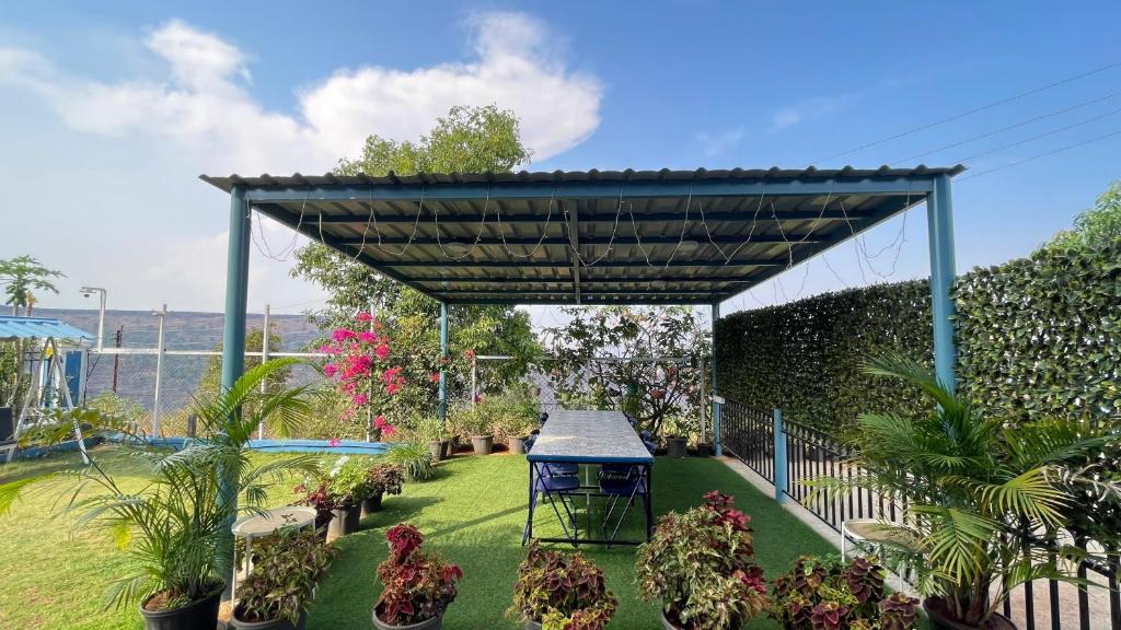 uma pérgola num jardim com vasos de plantas em The Loft em Panchgani