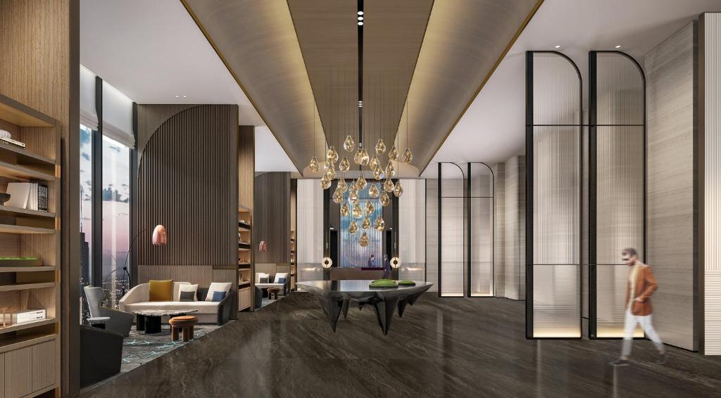 a person walking through a living room with a chandelier at Crowne Plaza Jinan Runhua in Jinan