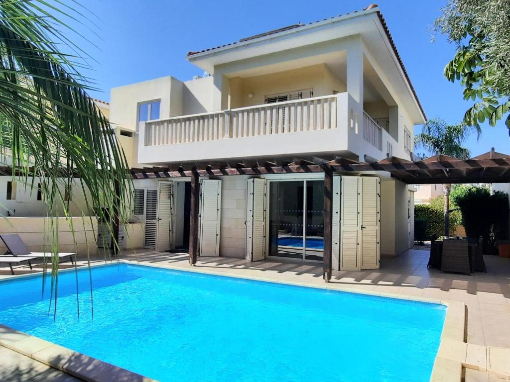 une villa avec une piscine en face d'une maison dans l'établissement Villa Larnaca Bay Resort, à Oroklini