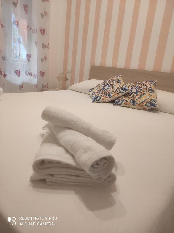 a pile of towels sitting on top of a bed at DA FEDERICA Casa Vacanze BAIA PORTO DELLE GENTI in Lipari