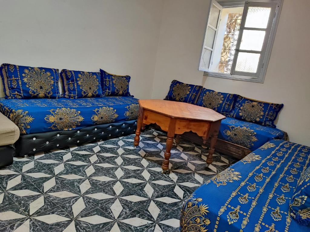 - un salon avec un canapé bleu et une table dans l'établissement Dardiyafa, à Azrou