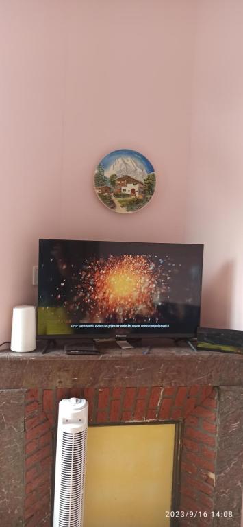 a flat screen tv sitting on top of a fireplace at Appartements touristique - La Colombière in Lourdes