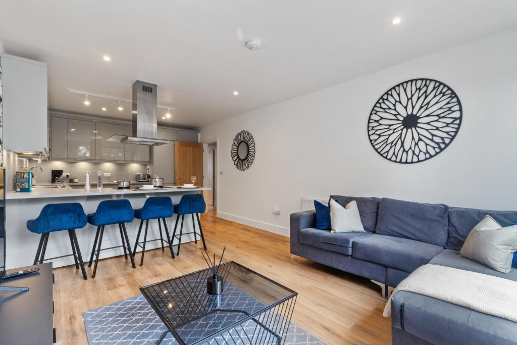 a living room with a blue couch and a kitchen at Private En-suite Double Rooms - 5 Minute Walk to Hendon Central Station - Reach Central London in just 21 Minutes in Golders Green