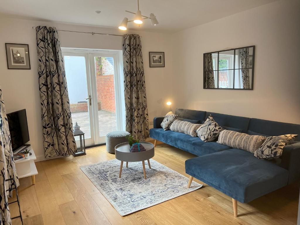 - un salon avec un canapé bleu et une table dans l'établissement Mews house in the centre of Henley-on-Thames, à Henley-on-Thames