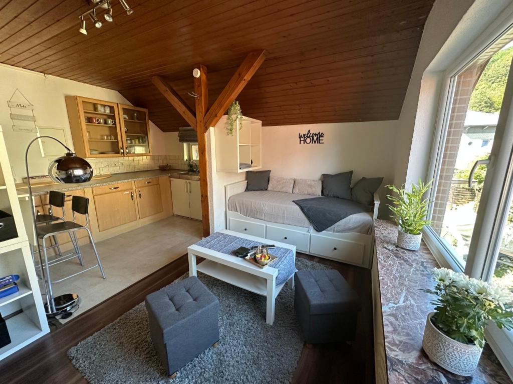 a small living room with a bed and a kitchen at Sauerlandapartment Vivien in Plettenberg