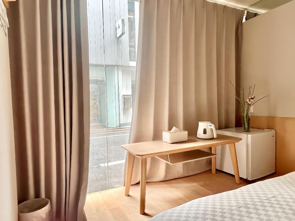 1 dormitorio con cama, mesa y ventana en 东京上野超级中心 设计师房间Yaob 上野公园3分钟 车站1分钟 超级繁华 免费wifi 戴森吹风, en Tokio