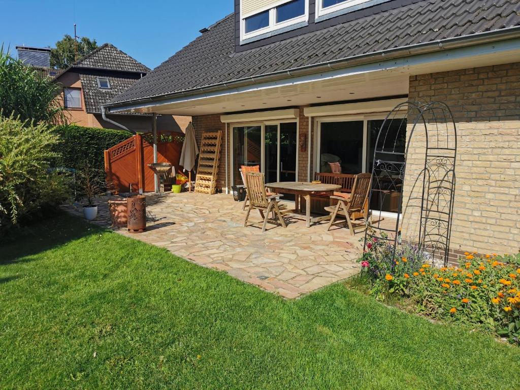 a patio with a table and chairs in a yard at traumhaft edle Landhauswohnung in Rosengarten