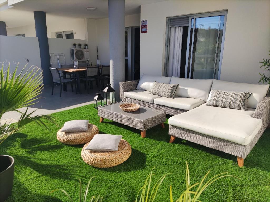 a living room with a couch and chairs and grass at COSTA MAGALLANES BEACH LA TEJITA in Granadilla de Abona
