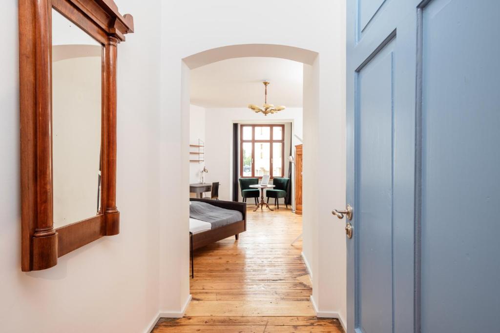 a hallway with a mirror and a bed at Künstlerzimmer im Kulturhaus Häselburg in Gera