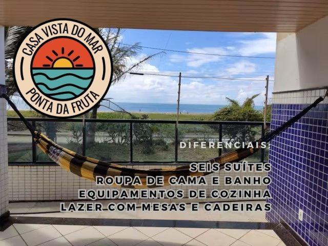ein Schild für ein Resort mit einer Hängematte auf dem Balkon in der Unterkunft Casa Vista do Mar, praia e piscina in Vila Velha