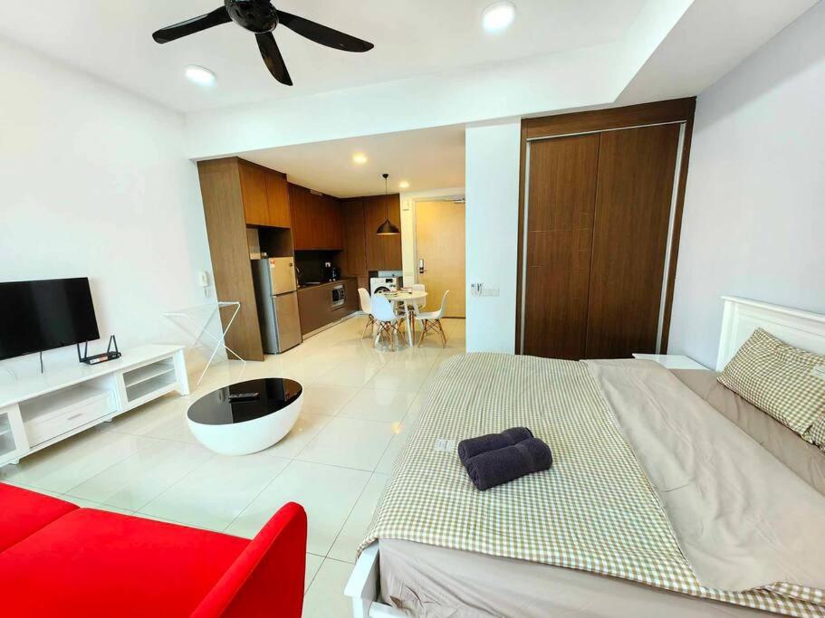 ein Schlafzimmer mit einem großen Bett und einem roten Sofa in der Unterkunft A3007 Grand Medini 100mbps Netflix By STAY in Nusajaya