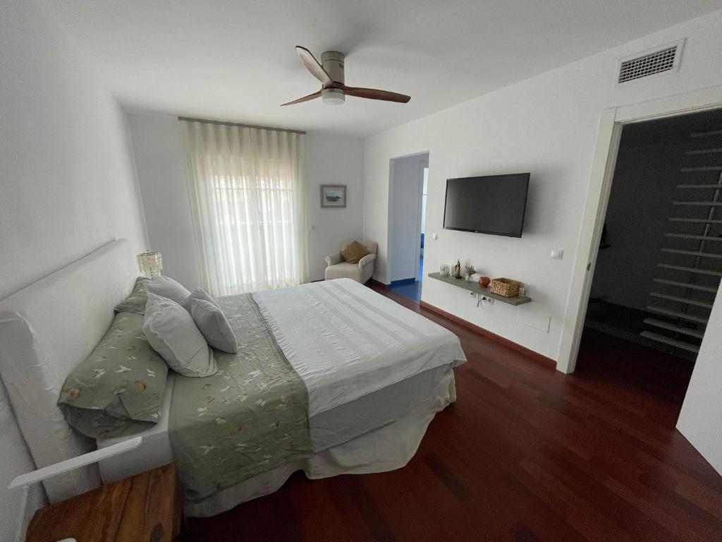 1 dormitorio con 1 cama y ventilador de techo en Tokyo Rooms (El Playazo) - Habitación PREMIUM con baño privado, en Almería